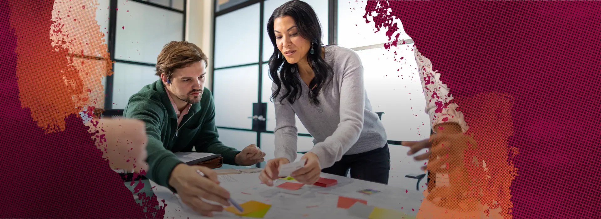 Two coworkers engaged in a brainstorming session with post-it notes